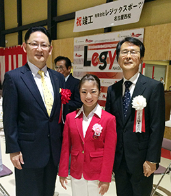 寺本明日香選手を囲む梅村清英理事長（左）と坂本周次代表（右）＝レジックスポーツ名古屋西校で