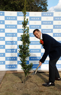 陸上競技場に記念の植樹をする室伏准教授