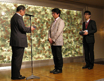 表彰を受ける橋本教授（中央）と秋月さん（右）